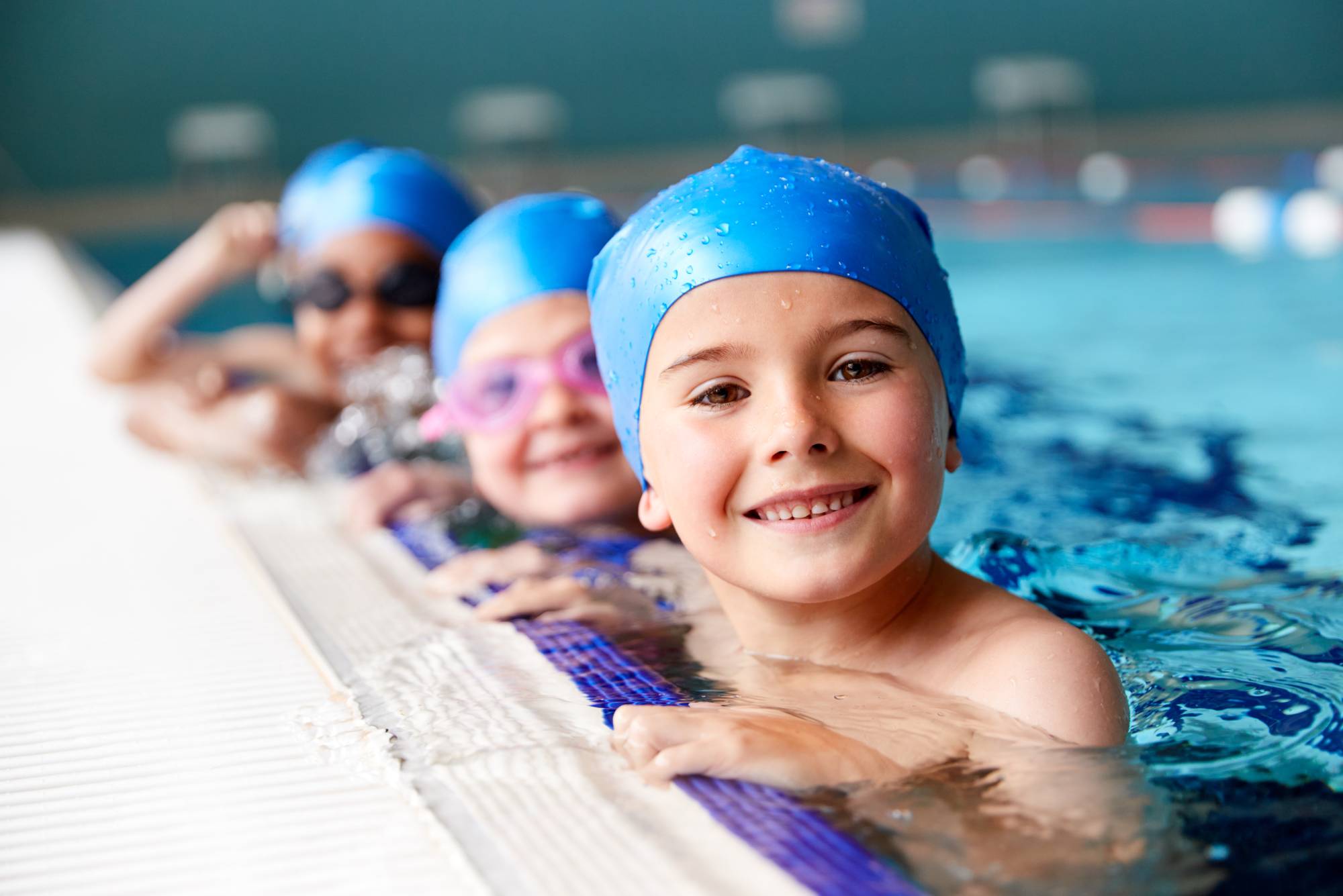 Children at edge of swimming pool waiting for lesson