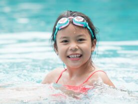 Girl in water with googles on head